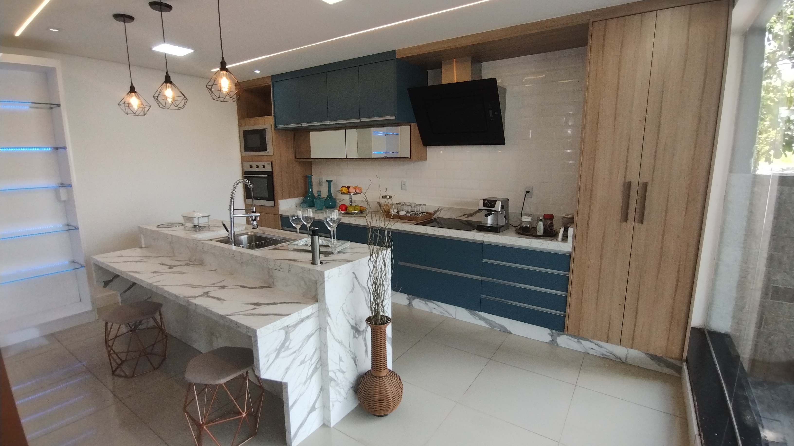 Cozinha planejada com ilha de mármore e acabamentos sofisticados